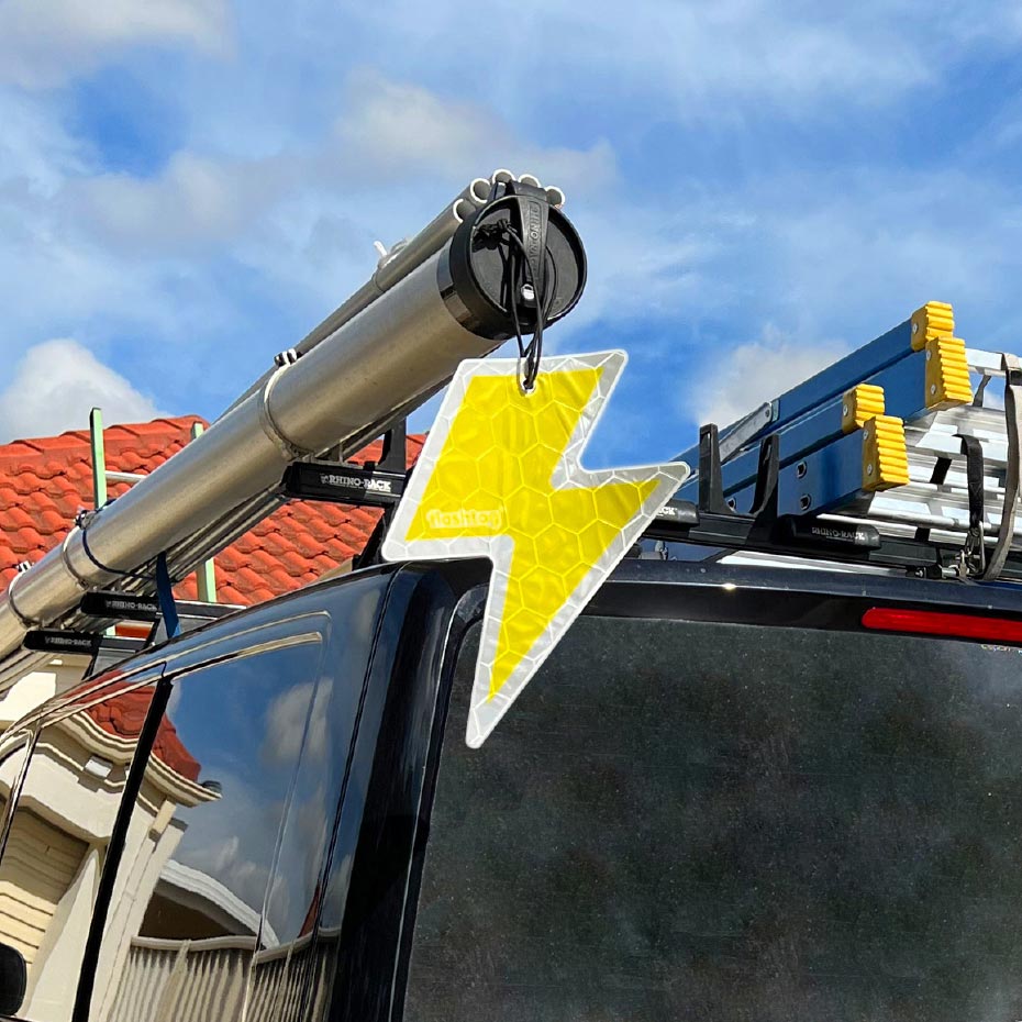 Flashtag Yellow Lightning Bolt reflector on the roof rack of an electrician's van